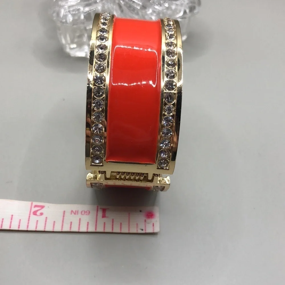 Gold tone enamel statement clamper bracelet.